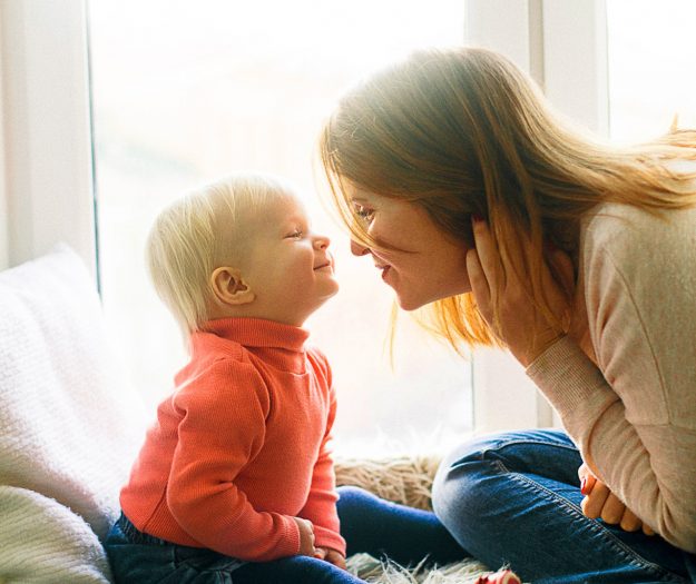 woman-and-child-sitting-on-fur-covered-bed-1257099